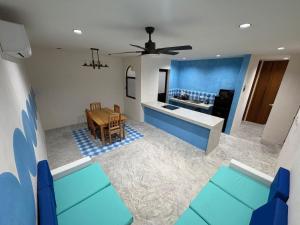 a living room with a table and a kitchen at Casa Laura Azul in El Cuyo
