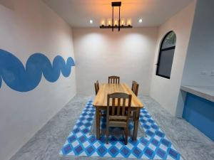 a dining room with a table and chairs on a blue floor at Casa Laura Azul in El Cuyo +2 photos