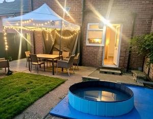 a fire pit in a backyard with a table and chairs at Bramcote House in Bramcote