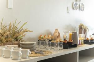ein Buffet mit Speisen auf einem Tisch mit Tellern und Gläsern in der Unterkunft Duna Queen Hotel Conceito in Barreirinhas