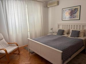 a bedroom with a large bed and a chair at Apartment 45 in Crikvenica