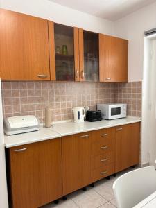a kitchen with wooden cabinets and a microwave at Apartment 45 in Crikvenica