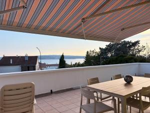 a wooden table and chairs on a balcony with a view at Apartment 45 in Crikvenica