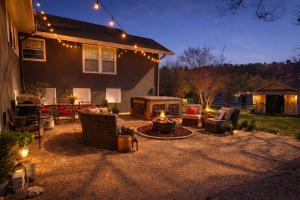 a backyard with a fire pit and chairs and lights at Smallville Farm Retreat in Lake Catherine