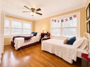 a bedroom with two beds and a ceiling fan at Smallville Farm Retreat in Lake Catherine