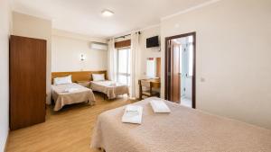 a hotel room with two beds and a living room at Arcádia by Umbral in Fátima