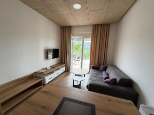 a living room with a couch and a table at Apartments Memories EV ch 11kW available in Trebinje