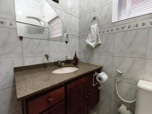 a bathroom with a sink and a mirror and a toilet at Casa Lyrata in Tatuí