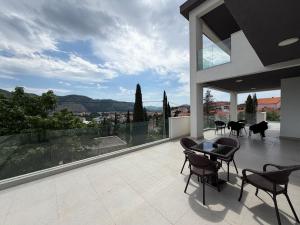a patio with chairs and a table on a balcony at Apartments Memories EV ch 11kW available in Trebinje