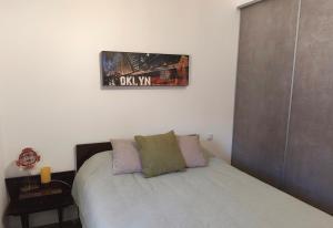 a bedroom with a bed and a picture on the wall at Appartement Cévenol in Le Vigan