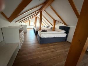 a attic room with two beds and a wooden floor at Apartments Memories EV ch 11kW available in Trebinje