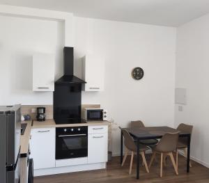 a kitchen with a table and a stove top oven at Appartement Cévenol in Le Vigan