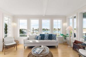 a living room with a couch and some windows at Waterfront Private Beach Gorgeous Views in Yarmouth