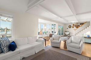 a living room with a white couch and two chairs at Waterfront Private Beach Gorgeous Views in Yarmouth