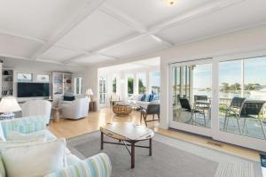 a living room with white furniture and a view of the water at Waterfront Private Beach Gorgeous Views in Yarmouth +30 photos