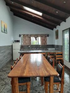 a dining room with a large wooden table and chairs at Hotel Monte Campana Heredia in Birrí
