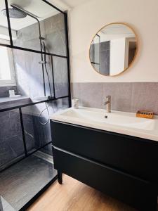 a bathroom with a black and white sink and a shower at Le Manana in Crozon +5 photos