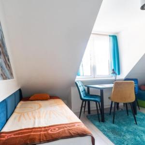 a small bedroom with a bed and a desk at Pensjonat Koral in Kołobrzeg