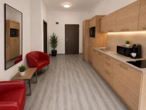 a room with a kitchen with a red chair and a counter at M14 Stay Cluj in Cluj-Napoca