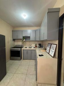 a kitchen with gray cabinets and a stove top oven at Departamento #1 in San Carlos