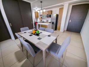 a kitchen with a wooden table and chairs with fruit on it at Bostor Apartament in San Salvador
