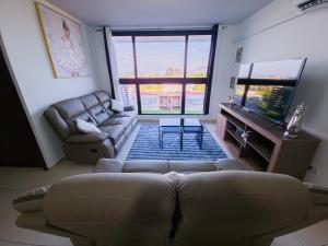 a living room with a couch and a television at Bostor Apartament in San Salvador