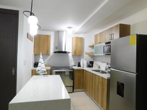 a kitchen with wooden cabinets and a white refrigerator at Bostor Apartament in San Salvador +21 photos