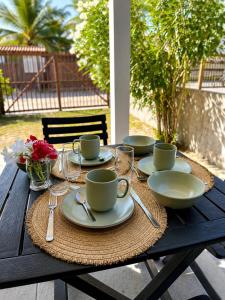 a table with plates and cups and utensils on it at Atins Suites in Atins