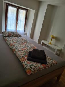 a bed with a black purse sitting on top of it at Ca' di Fant Malvaglia in Malvaglia