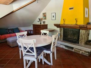 a living room with a table and chairs and a fireplace at Ca' di Fant Malvaglia in Malvaglia