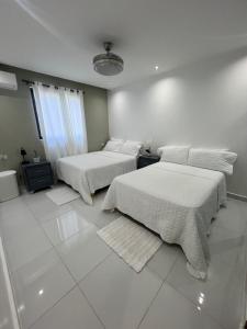 two beds in a room with white walls and white floors at Las margaritas in La Pascuala