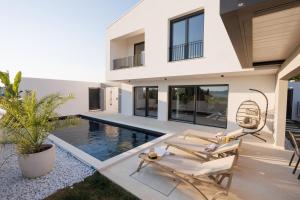 a house with a swimming pool in front of it at Villa Marcello in Zadar