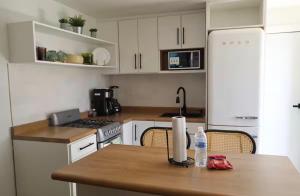 a kitchen with white cabinets and a wooden table at Bello loft studio en el corazón de Tijuana in Tijuana