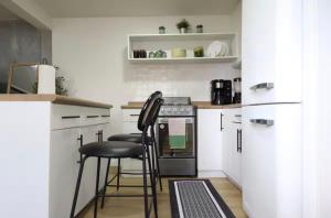 a kitchen with a stove and two stools in it at Bello loft studio en el corazón de Tijuana in Tijuana +12 photos