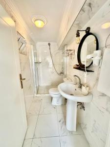 a white bathroom with a sink and a toilet at Hil Ada 1 in Bozcaada