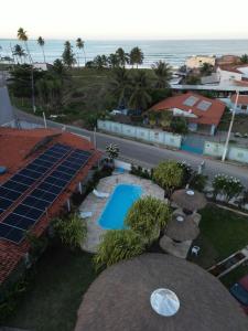 an aerial view of a resort with a swimming pool and the ocean at Pousada Parque dos Coqueiros in Piaçabuçu