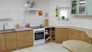 a kitchen with wooden cabinets and a white stove top oven at Pensjonat Anna in Osłonino