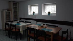 a dining room with two tables and two windows at Pensjonat Anna in Osłonino +9 photos