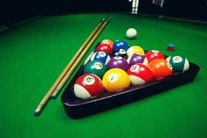 a group of billiard balls and cues on a pool table at Penzión Ingrid in Štrbské Pleso