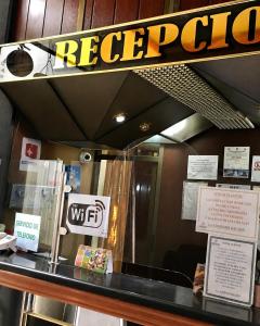 a restaurant counter with a sign on the window at Hotel Beirut Oruro in Oruro