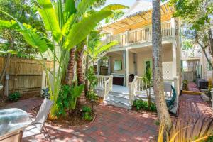 a house with palm trees in front of it at Turtle Nest Condo - Pool - 2nd Floor in Key West
