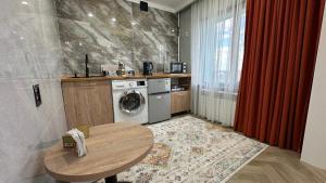 a kitchen with a table and a washing machine at Yuzhnaya in Qyzylorda