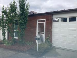 a red brick house with a white garage door at Fountain Villa in Camberwell