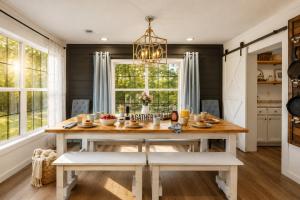 a dining room with a table and a chandelier at Smallville Farm Retreat in Lake Catherine
