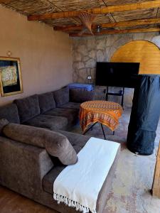 a living room with a couch and a tv at Hostal Desert in San Pedro de Atacama