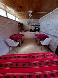 a room with tables and chairs and a kitchen at Hostal Desert in San Pedro de Atacama
