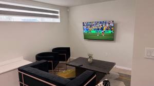 a living room with a tv on a wall at Dans luxury suite in Winnipeg