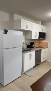 a kitchen with white cabinets and a white refrigerator at Dans luxury suite in Winnipeg