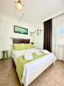 a bedroom with a large bed with green and white sheets at Hil Ada 1 in Bozcaada +14 photos