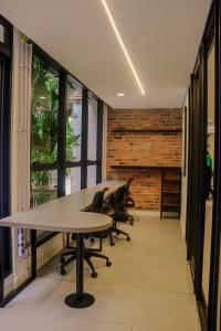 an office with tables and chairs and a brick wall at TBG Studios in Curitiba